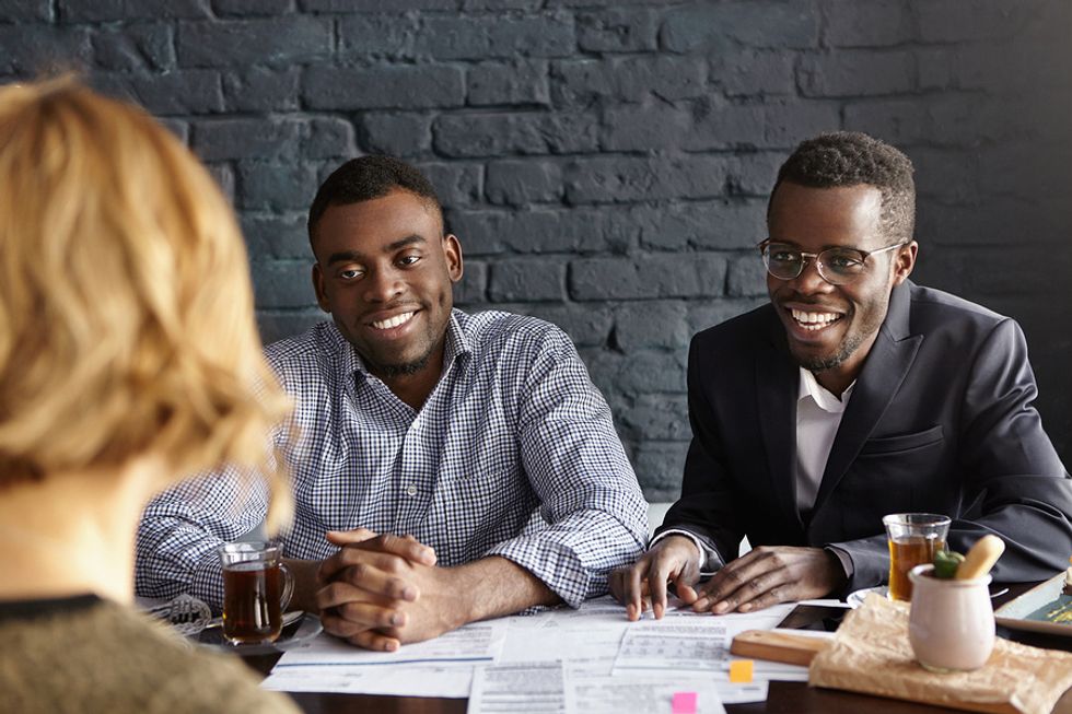 Hiring managers smile while interviewing a job candidate