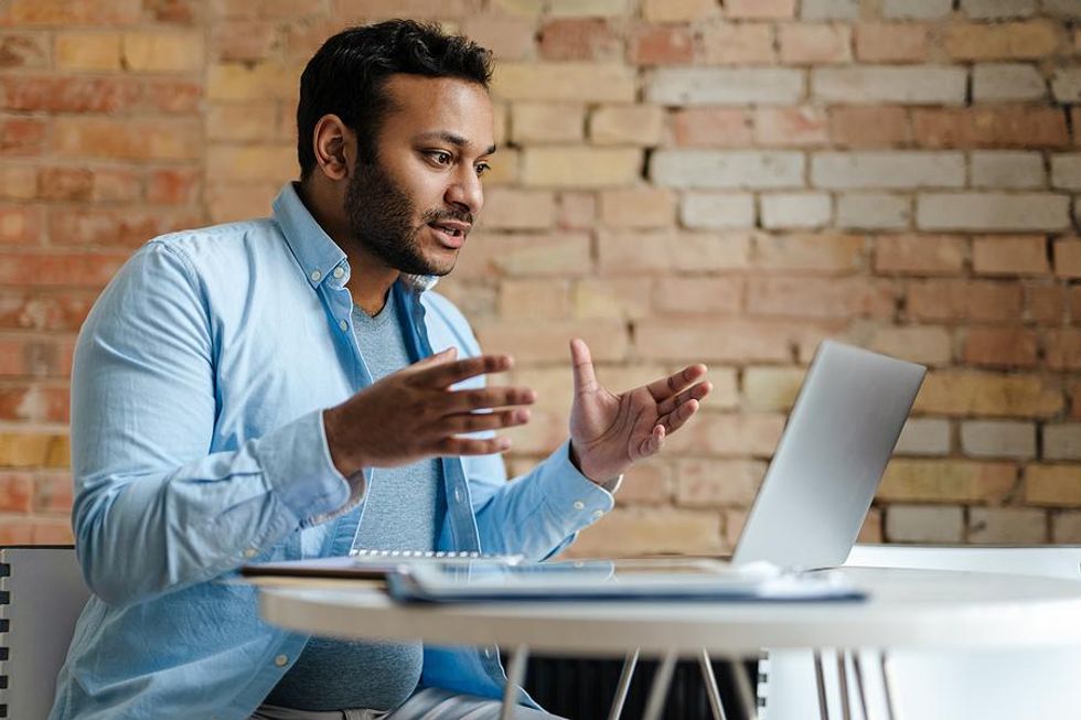 Hybrid employee talks during a virtual meeting