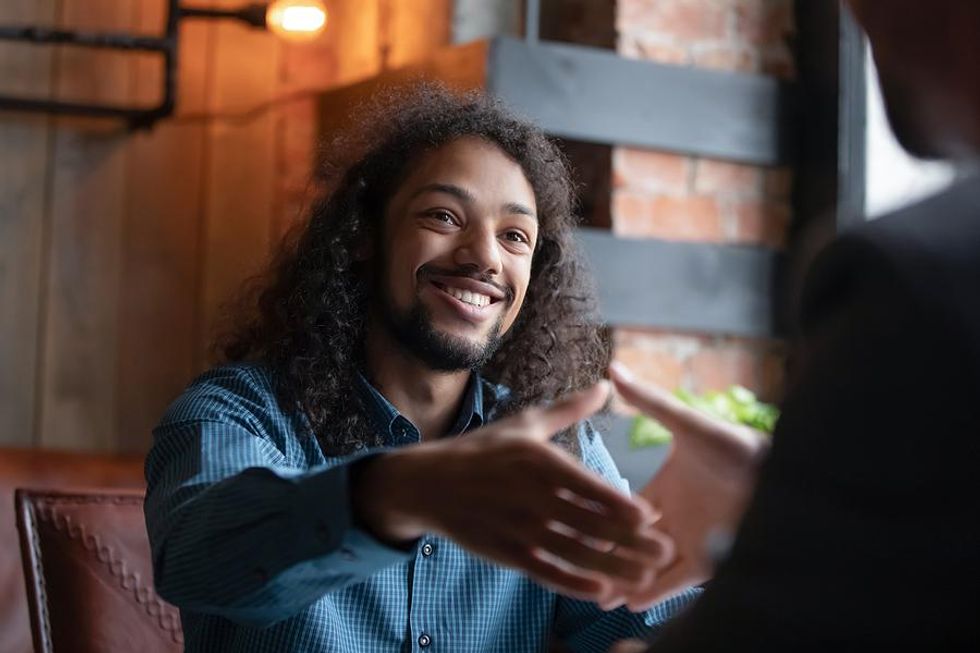 Interesting job candidate shakes hands with the hiring manager after an interview