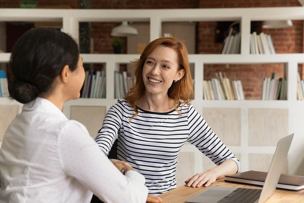 Interesting woman shakes hands with the hiring manager before an interview