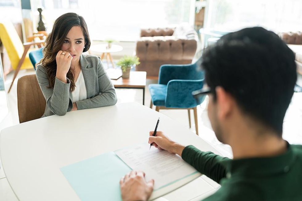 Job candidate gets nervous when the hiring manager reads her resume during an interview