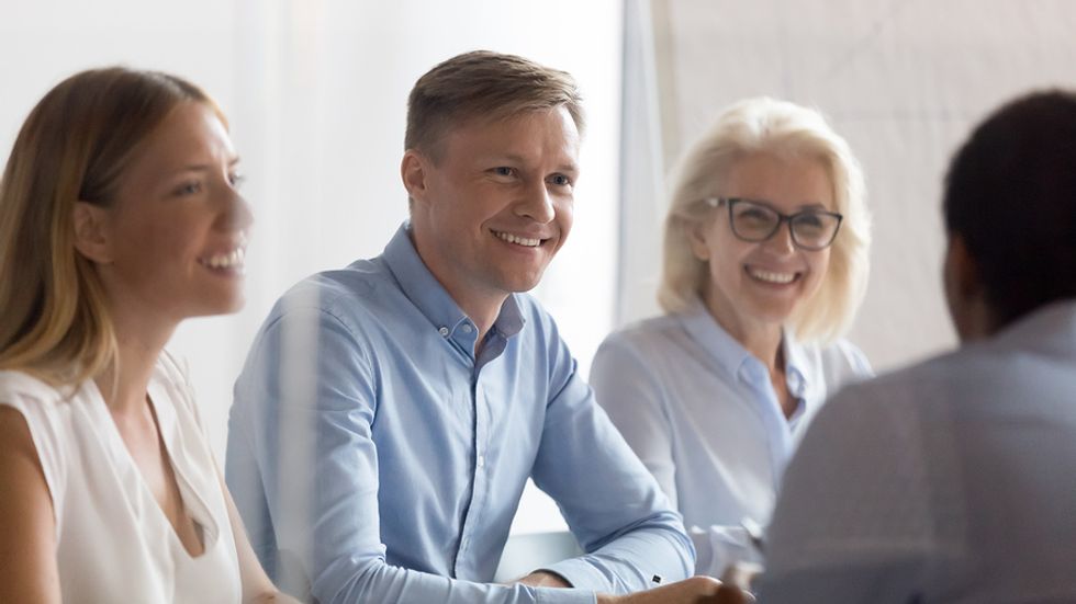 Job candidates smile during a group interview