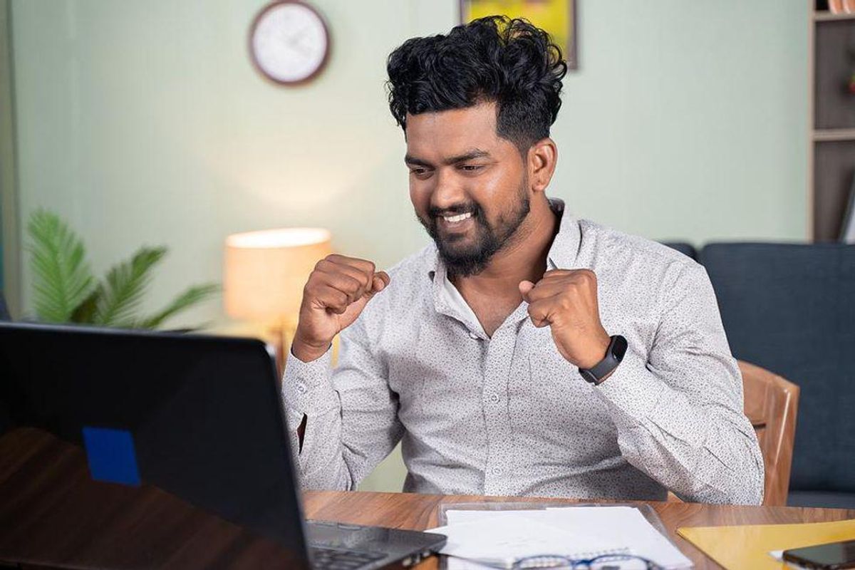 Job seeker celebrates after receiving a job offer in his email.