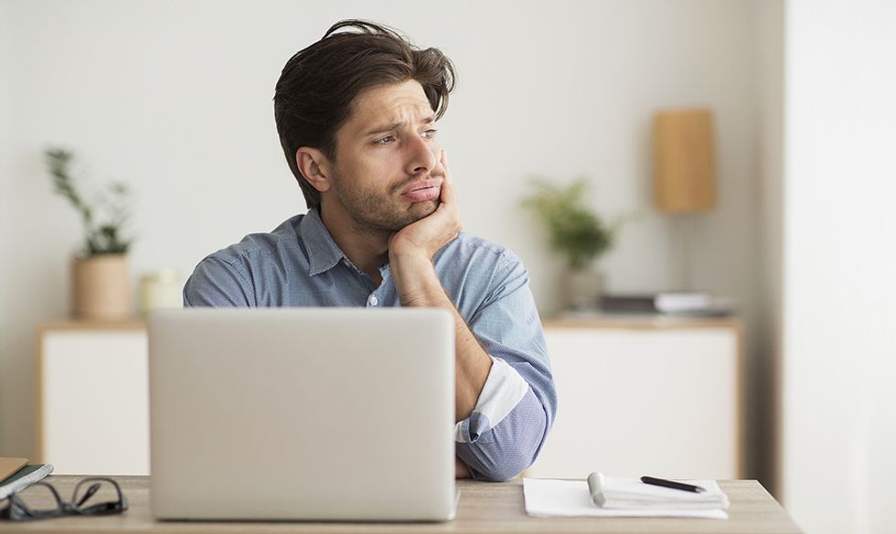 Job seeker on laptop shows a lack of interest in working on his resume