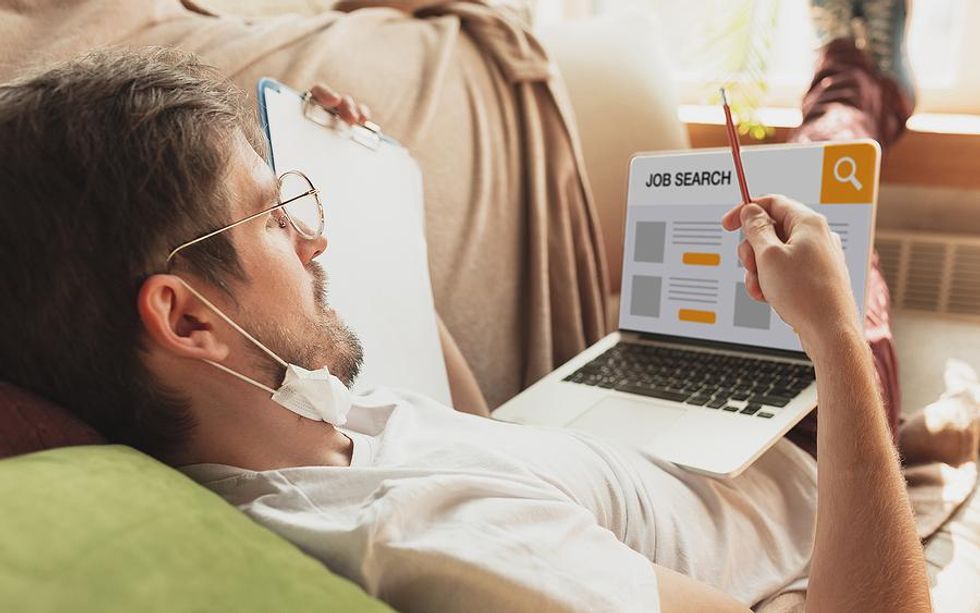 Job seeker on laptop works on his resume