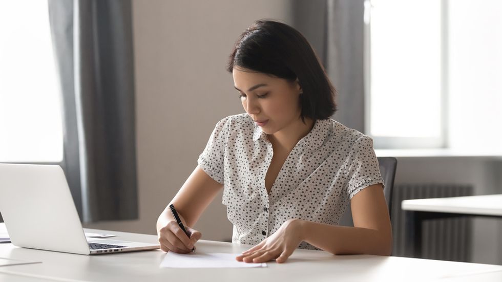 Job seeker on laptop writing an outstanding personal branding statement