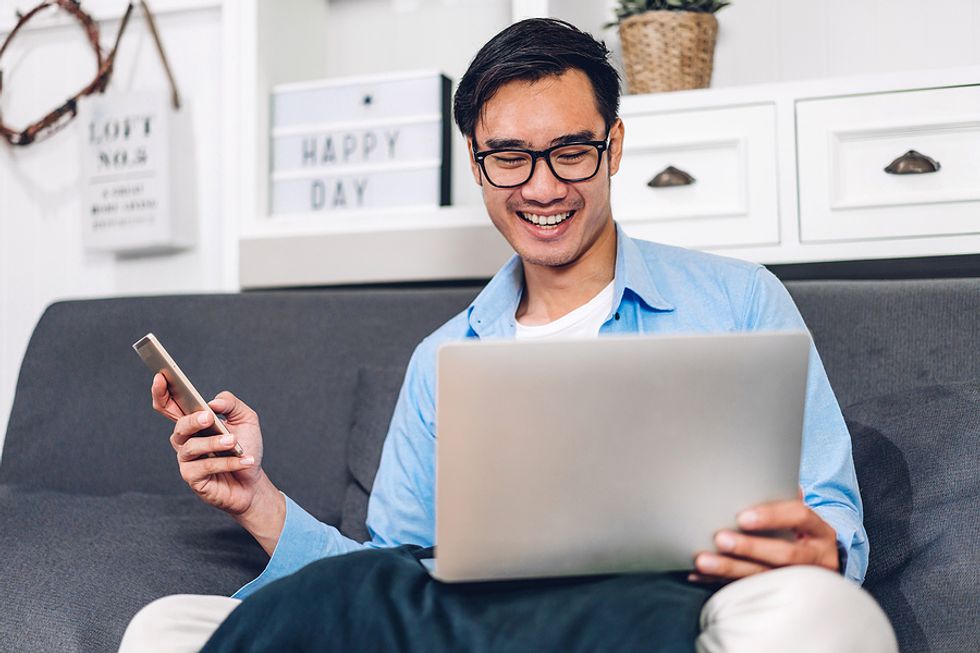 Job seeker on phone and laptop quantifies information on his resume