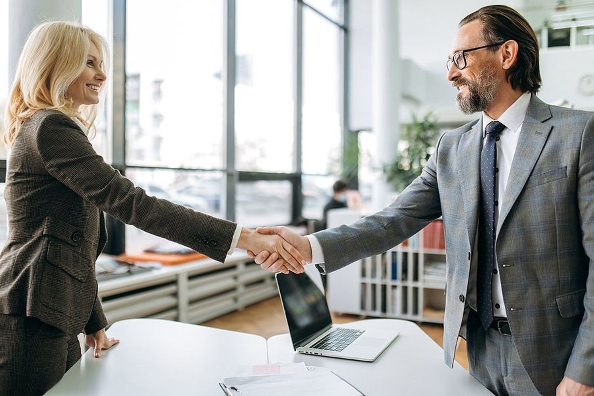 Job seeker shakes hands with the hiring manager before a job interview 