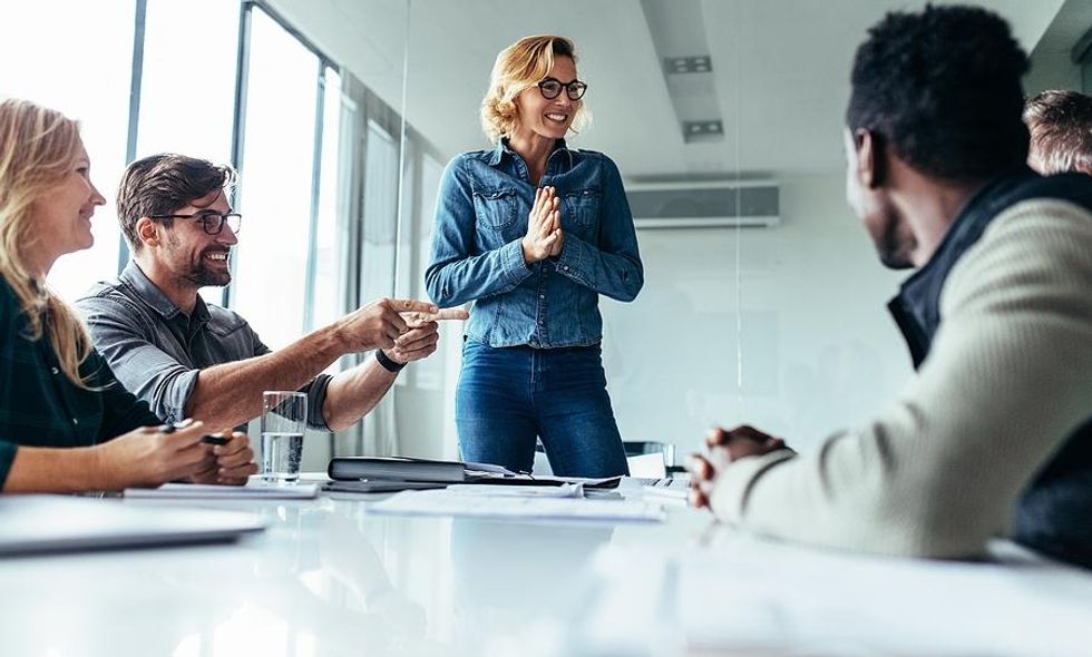 Leader/CEO talks to her team during a work meeting