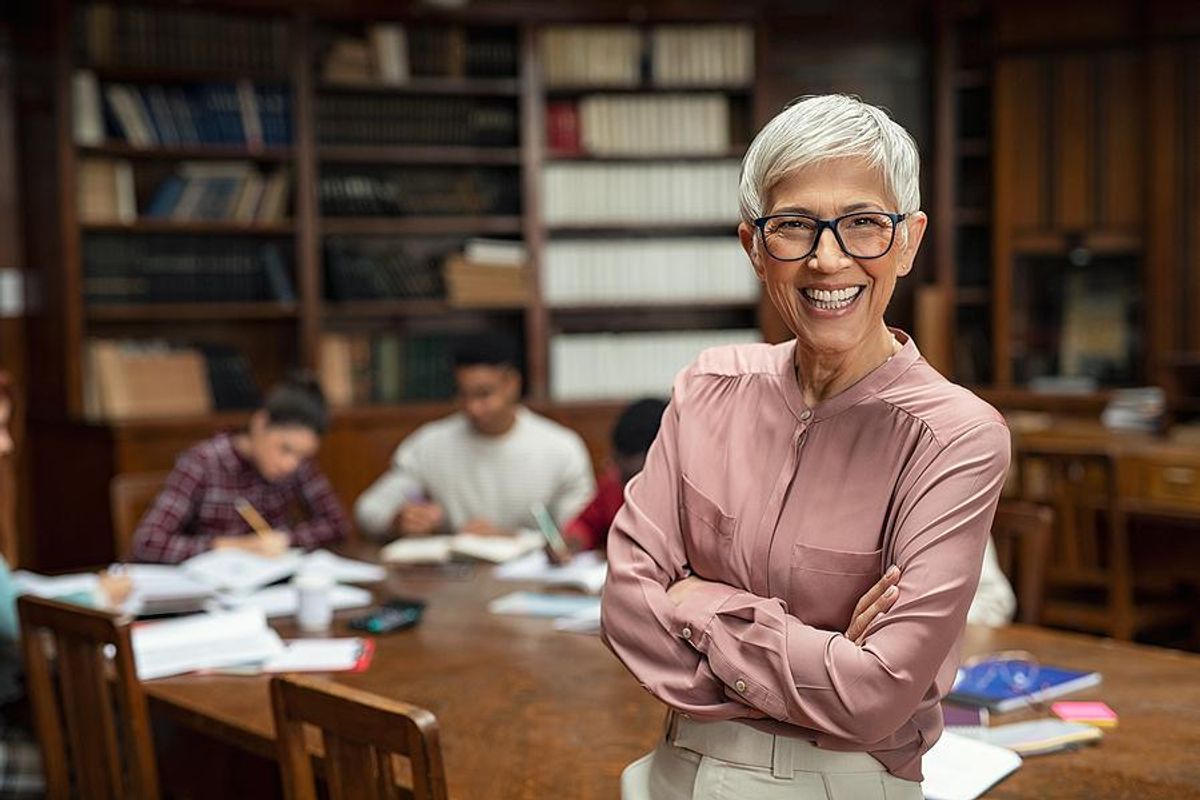 Librarian smiles in front of students studying