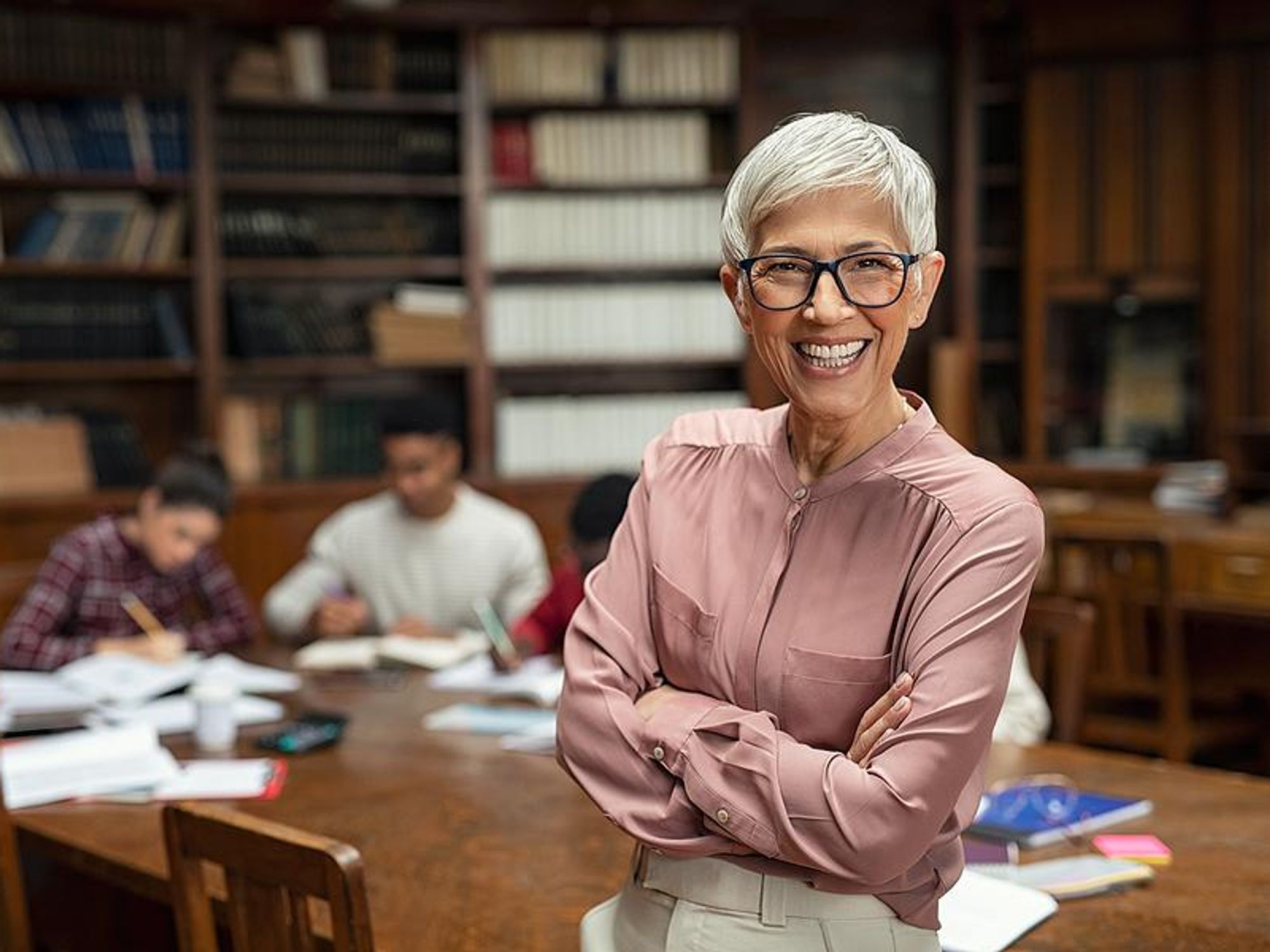 Librarian smiles in front of students studying