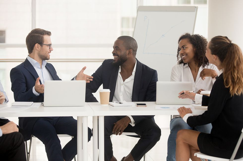 Male leader talking to his coworkers about personal leadership skills in a work meeting