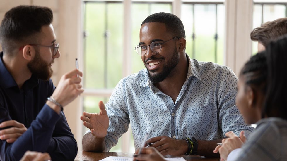Male manager using his influential soft skills to meet with his team