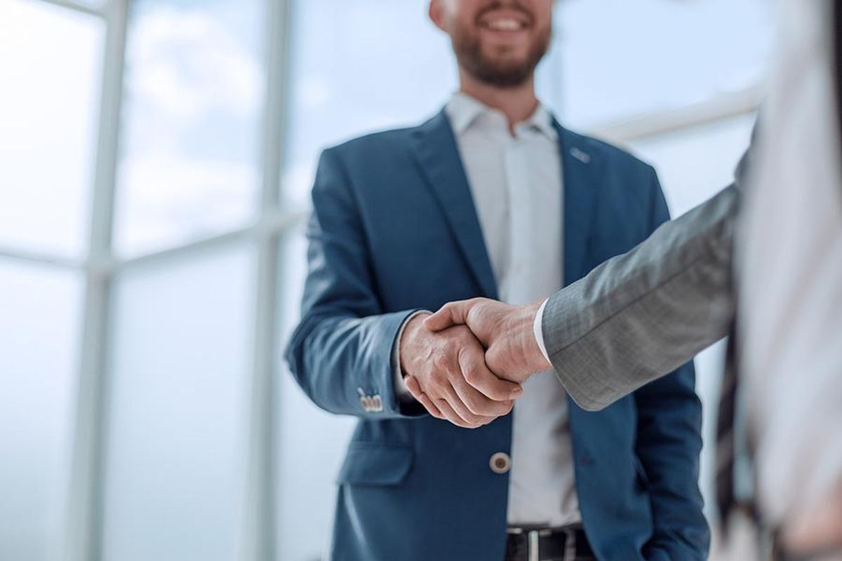 Man accepts a job offer and shakes hands with the hiring manager
