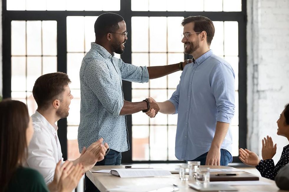 Man congratulates a coworker on his accomplishments