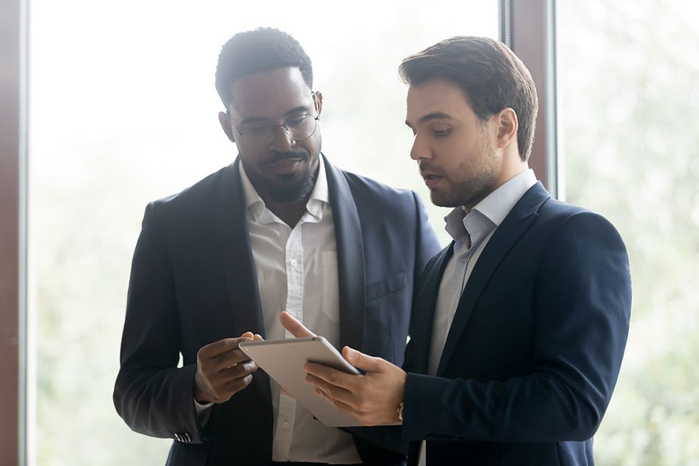 Man displays intangible skills at work while talking to his coworker