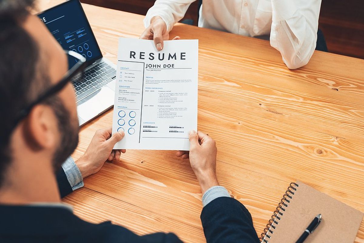 Man hands a hiring manager his resume without any mistakes