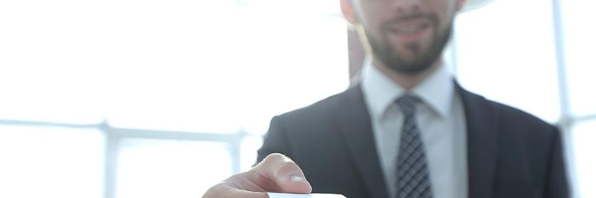 Man hands out his business card during a networking event