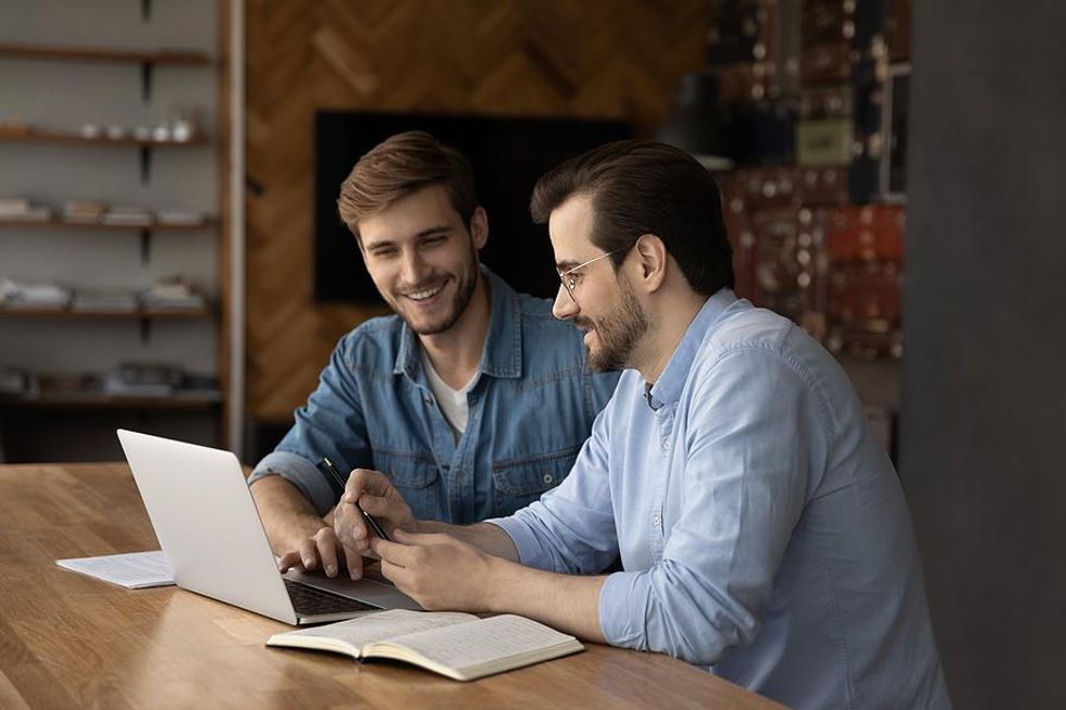 Man helps his work buddy with his new job