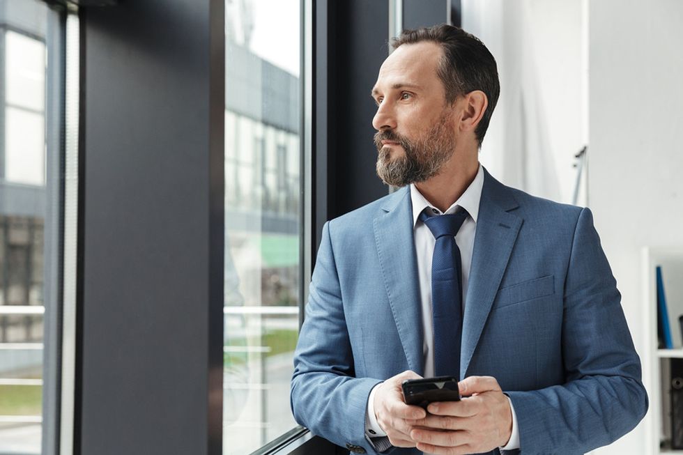 Man holding phone reflects on being laid off