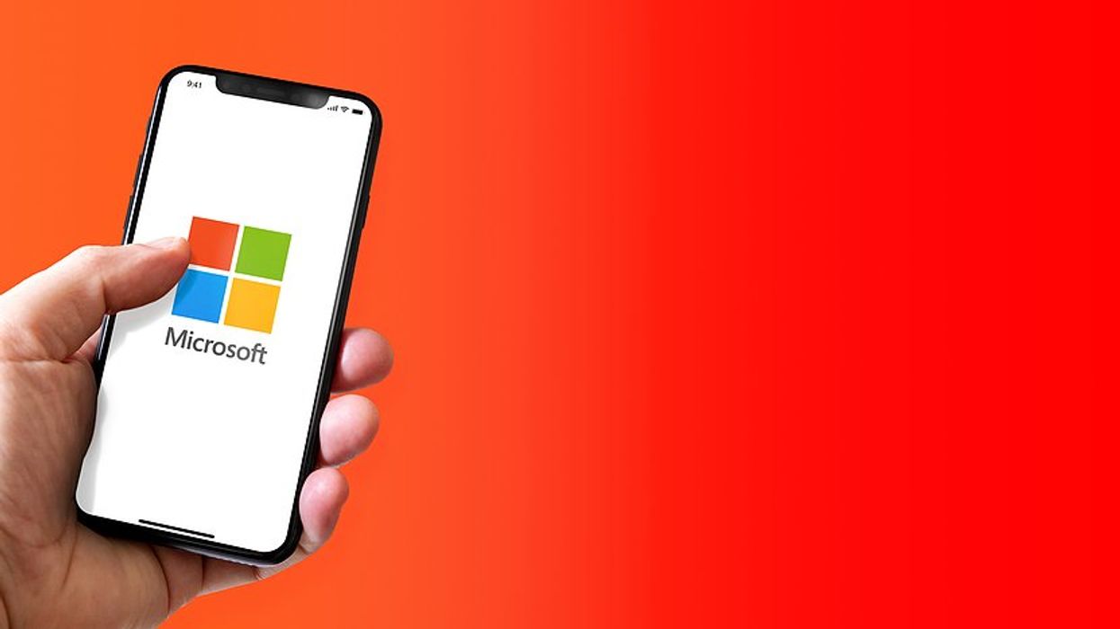 Man holds a phone powered by Microsoft Windows
