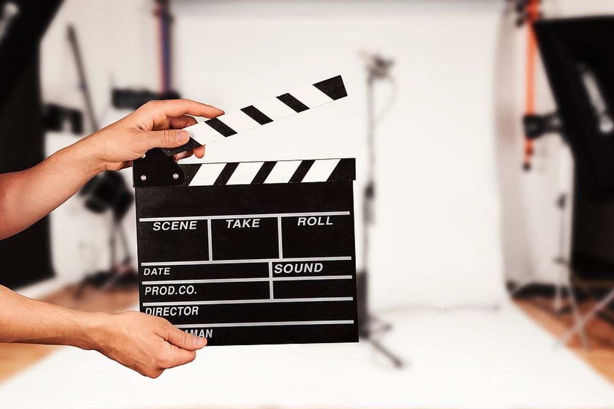Man holds film clapper in a film studio (entertainment industry concept)
