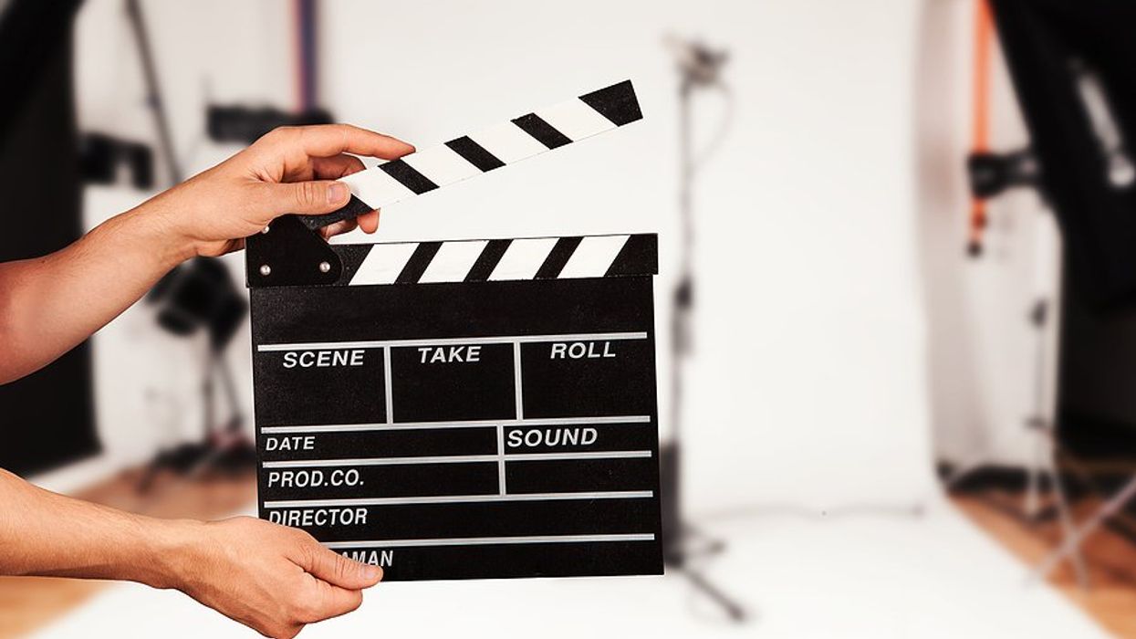 Man holds film clapper in a film studio (entertainment industry concept)