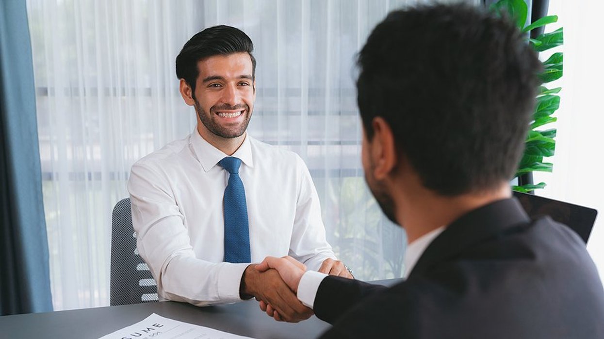 Man in a job interview shakes hands with the hiring manager after landing a higher-level job