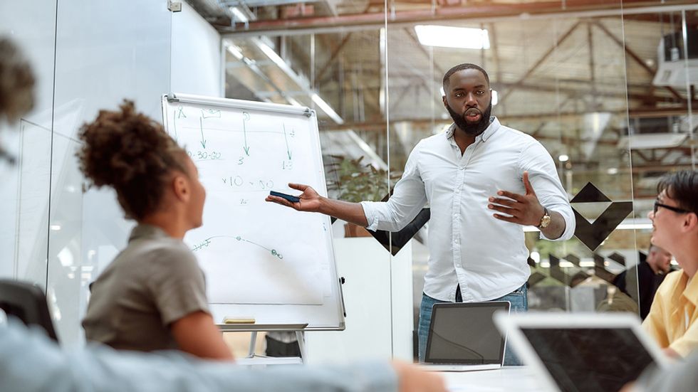 Man in work meeting takes on a challenge at work to develop new skills