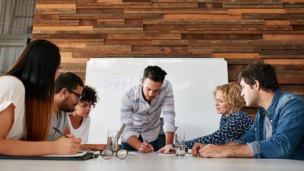 Man leads his team at work