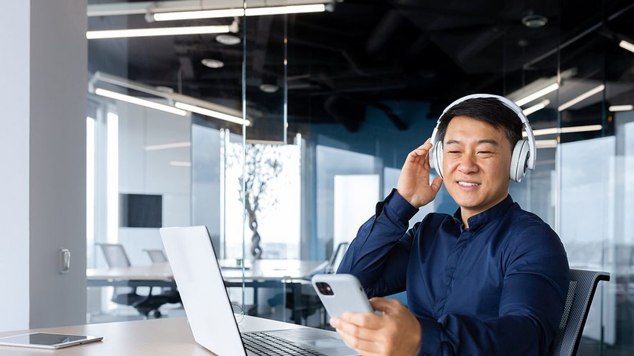 Man listens to a professional development podcast at work