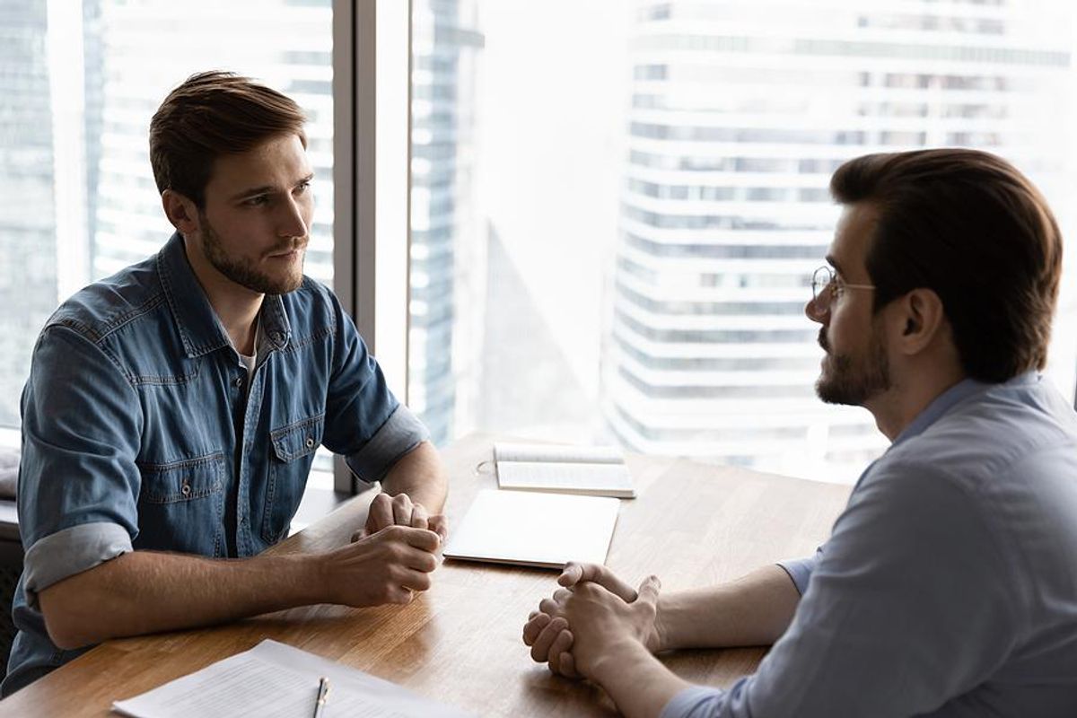 Man listens to boss during a meeting