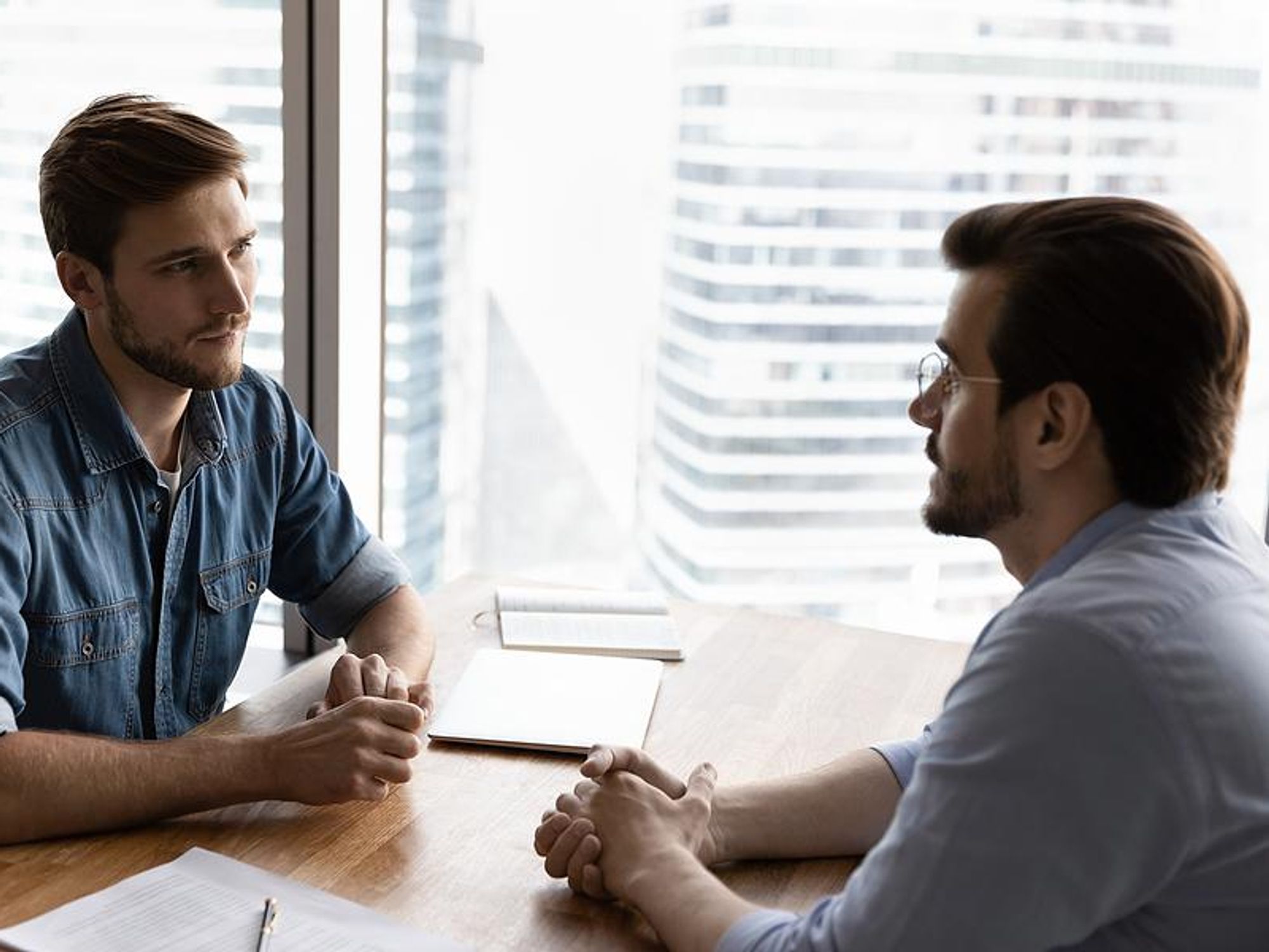 Man listens to boss during a meeting