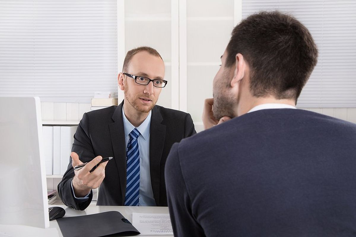 Man listens to his boss give him a bad performance review