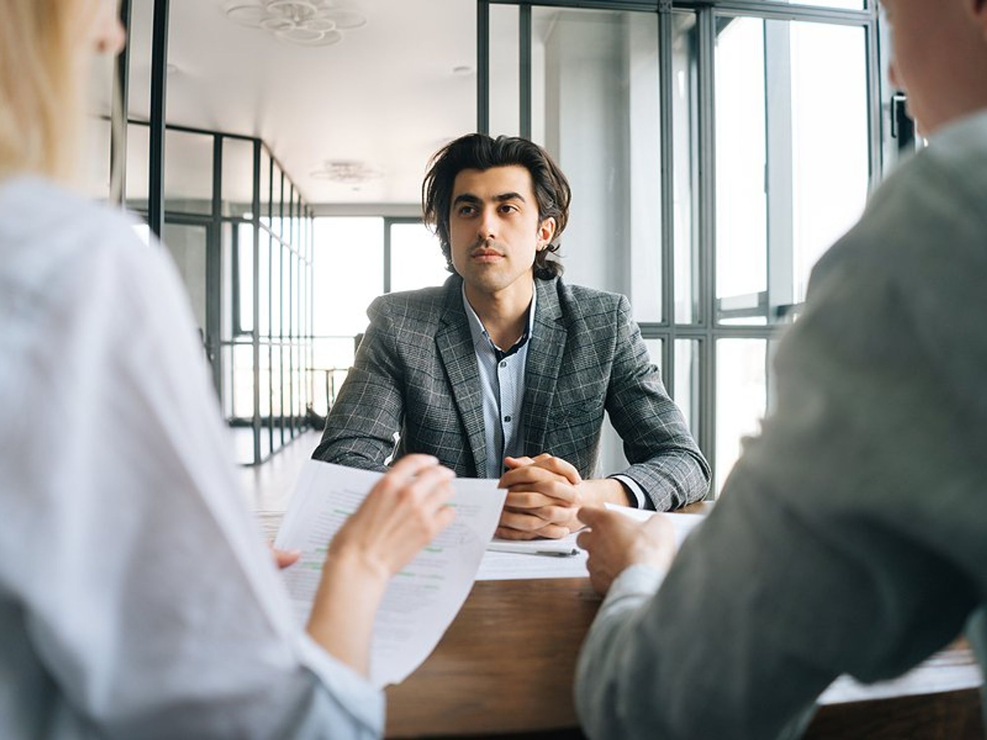 Man listens to the hiring manager ask a question during a job interview