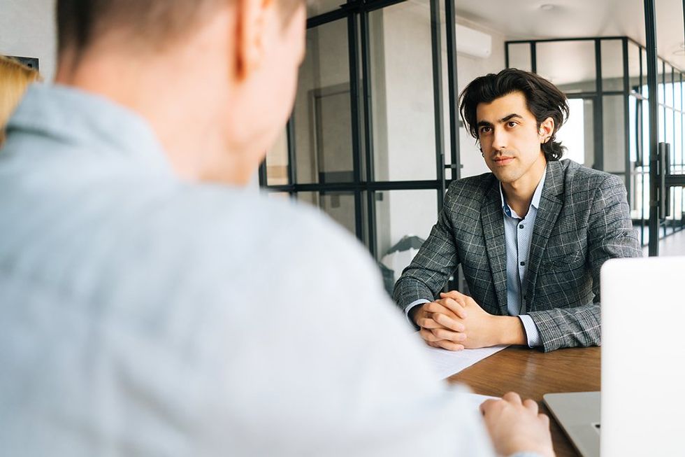 El hombre escucha al entrevistador/gerente de contratación durante la entrevista de trabajo