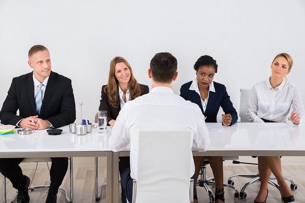 Man looks at hiring managers during a panel interview
