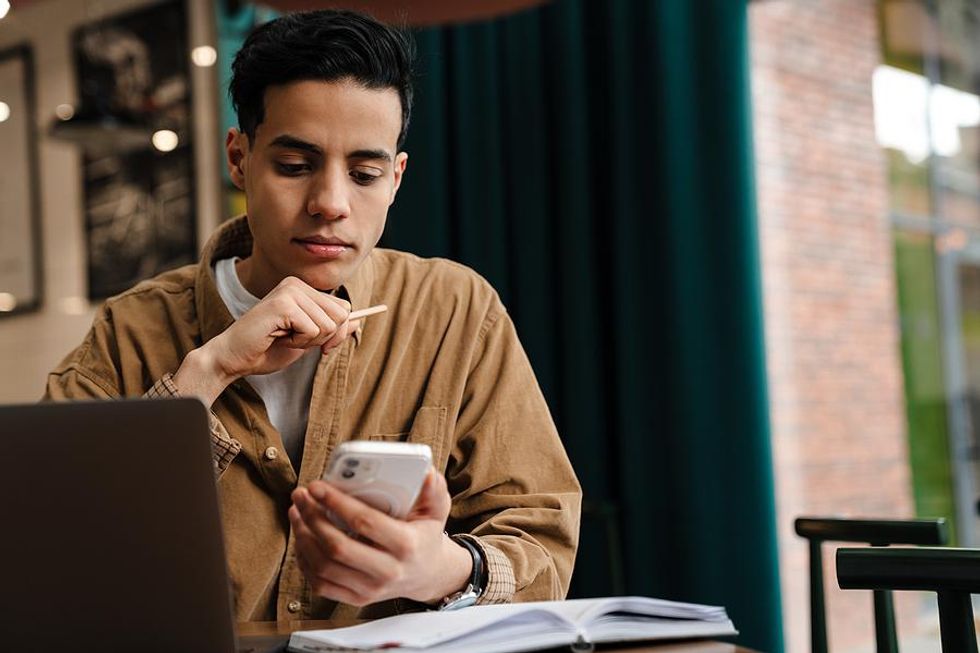 Man looks at his phone while researching companies to work for