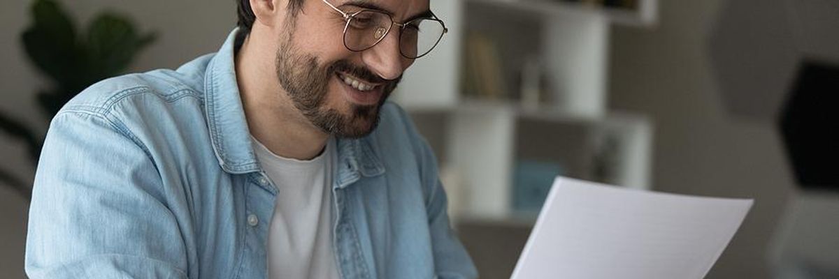 Man looks at his resume while updating his LinkedIn profile