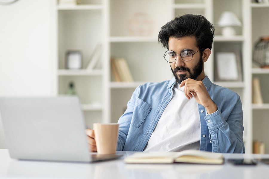 Man looks at MBA programs on his laptop