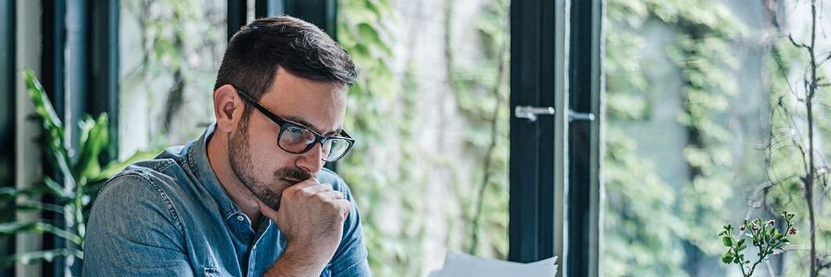 Man looks at some papers while he works