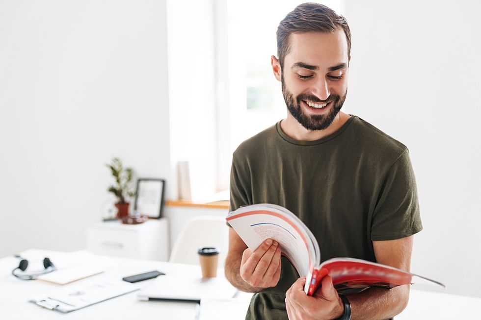 Man looks in a trade publication to find the name of a hiring manager