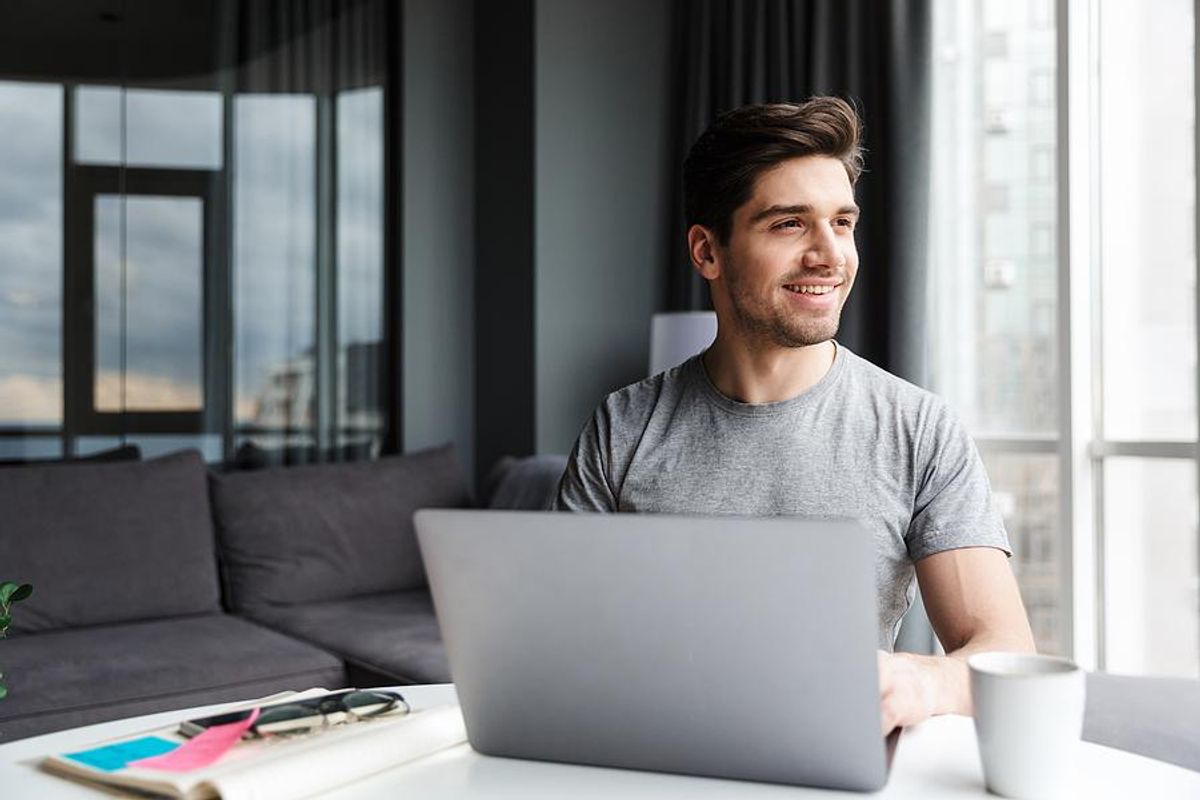 Man looks out the window while he writes