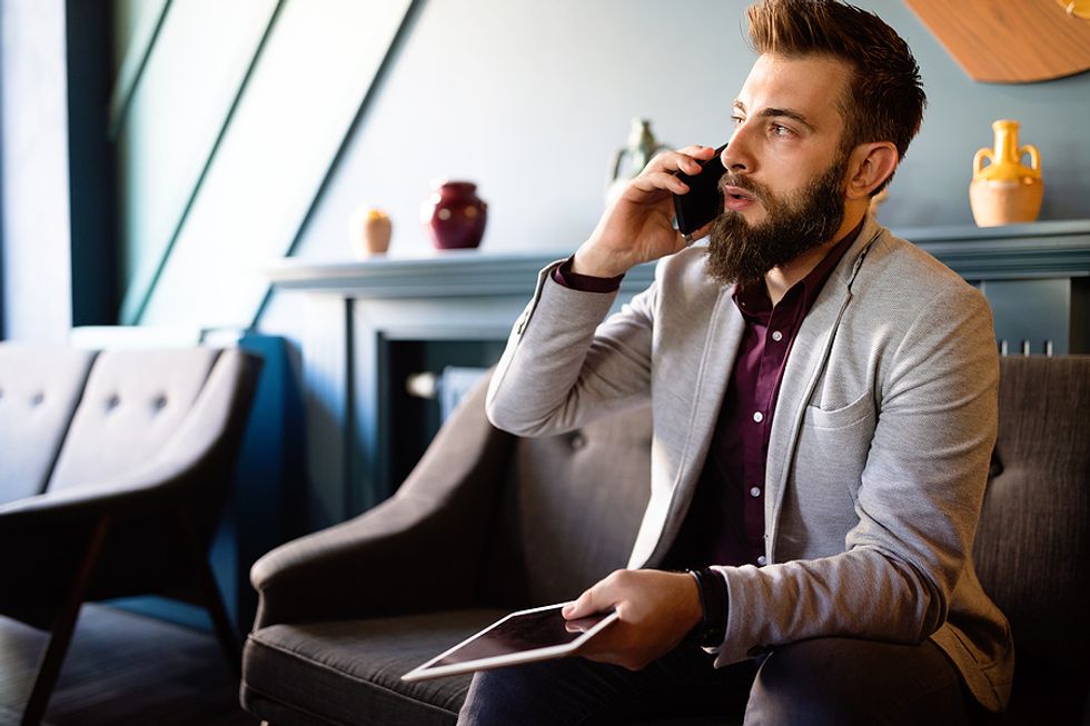 Man makes a phone call while looking for a job