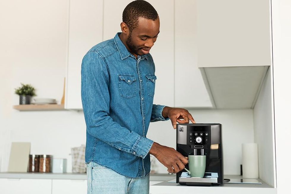 Man makes himself a cup of coffee at home