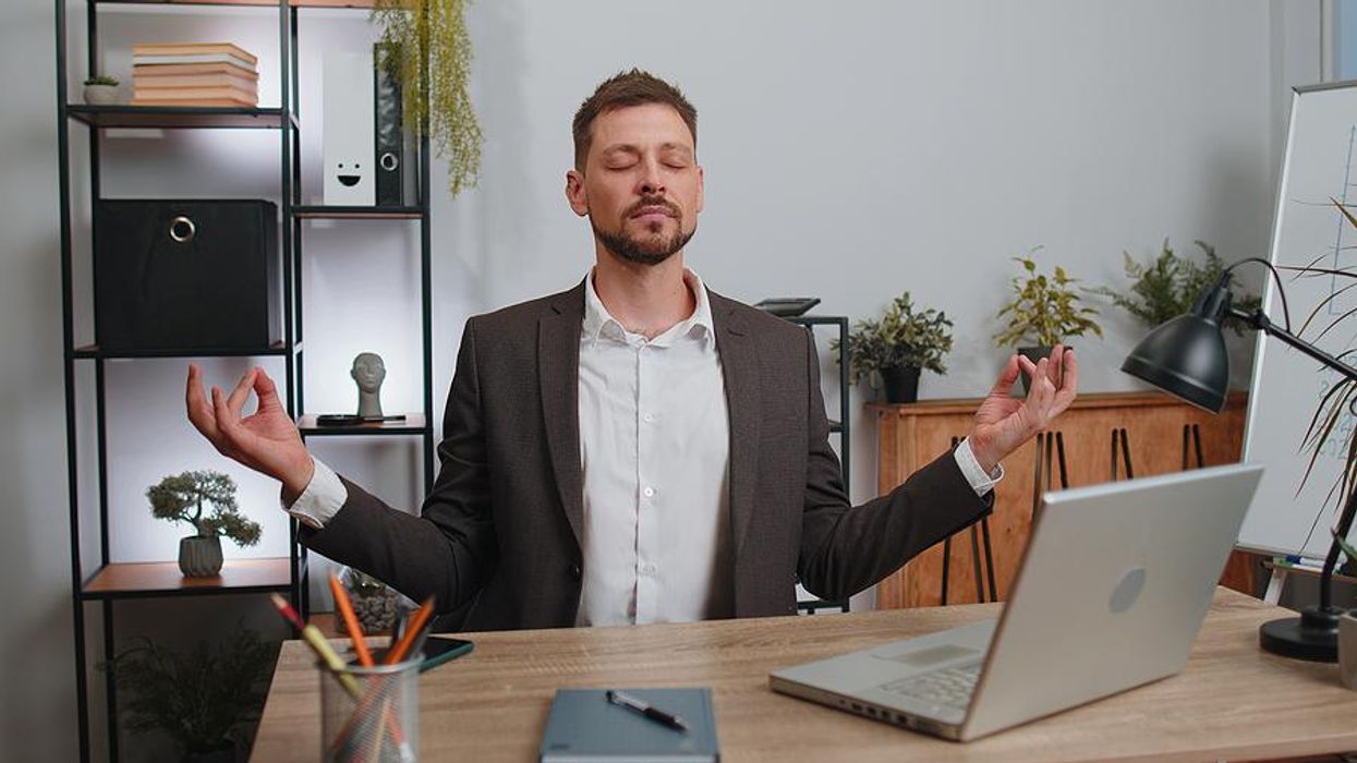 Man meditates, takes a breath, to stay mindful and present at work