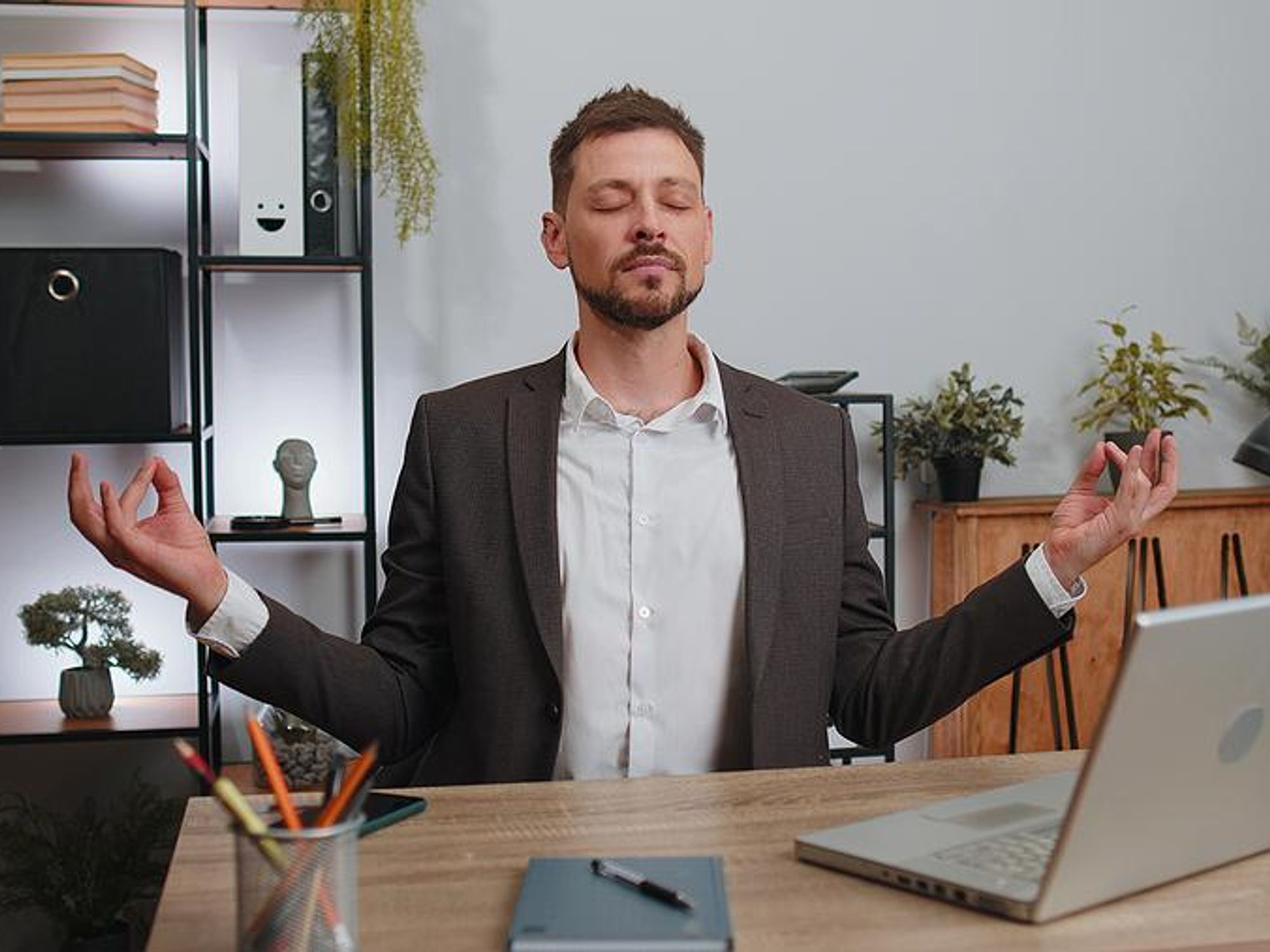 Man meditates, takes a breath, to stay mindful and present at work