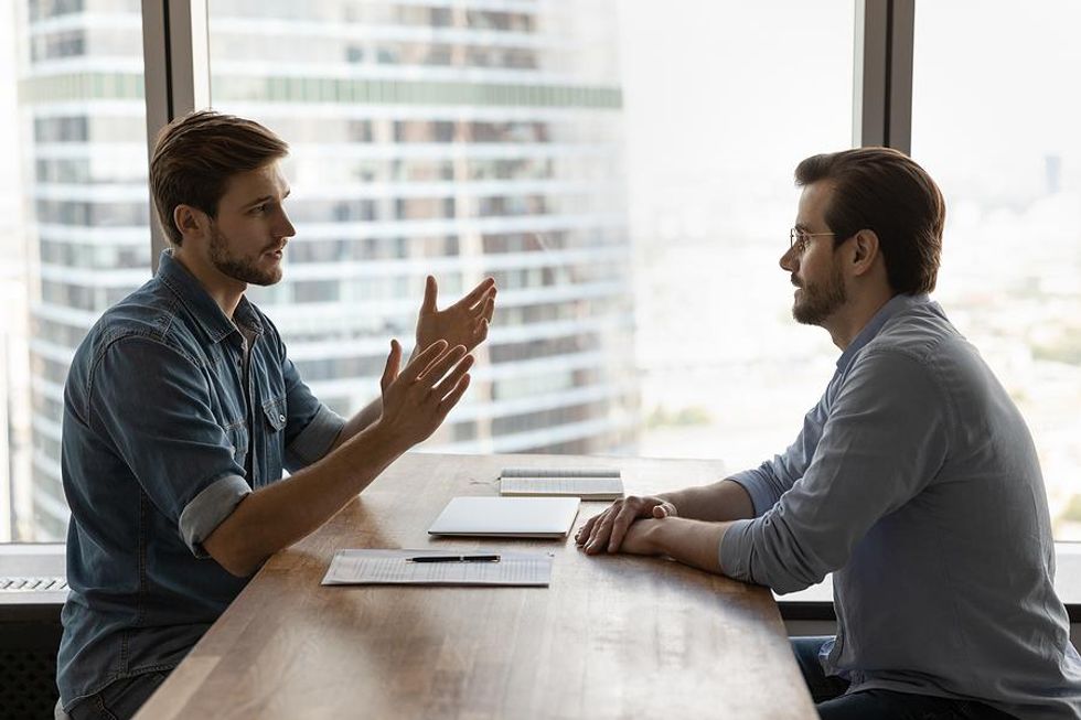 Man meets with his boss to discuss his workload