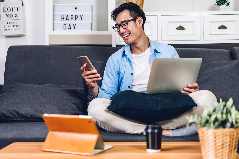 Man on laptop and phone looks up resume writing tips