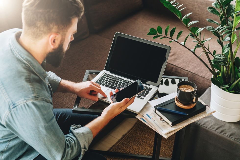 Man on laptop and phone prepares to work from home